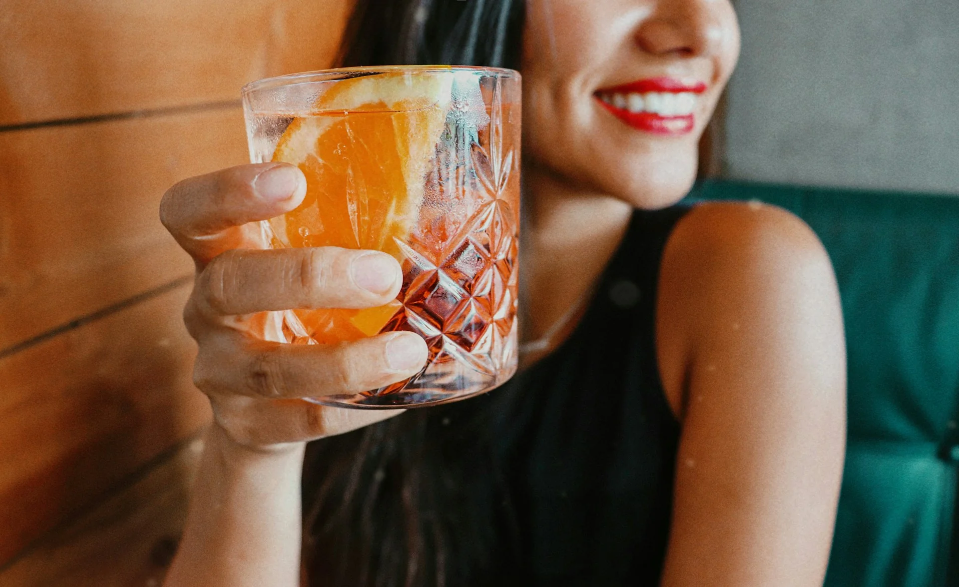 A woman smiles while drinking out at a bar