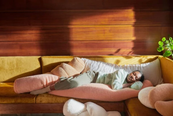 A woman snuggles with her Buffy Wiggle Pillow on her couch