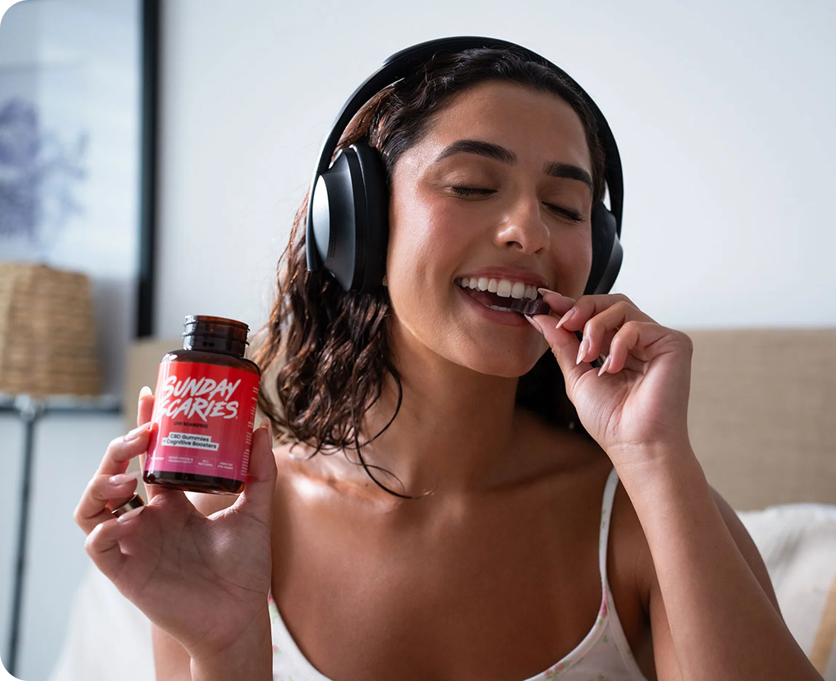 Woman holding gummies bottle with headphones