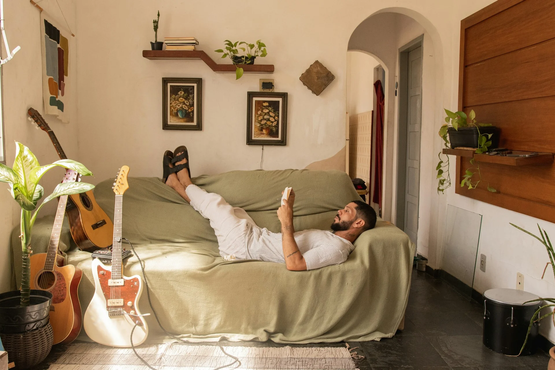 A man reads a book on the soda, relaxing in a nice environment, after drinking Kava root