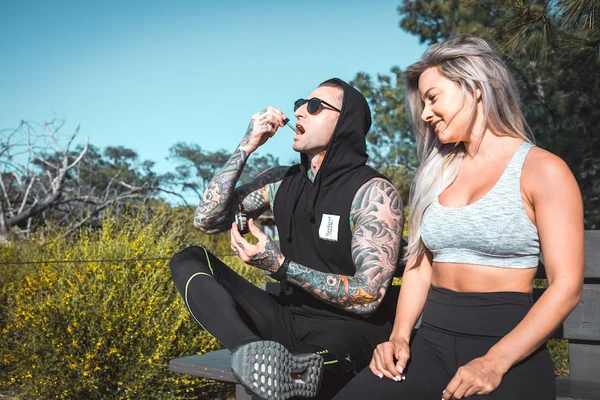 A male hiker consumes Sunday Scaries CBD Oil while his girlfriend watches