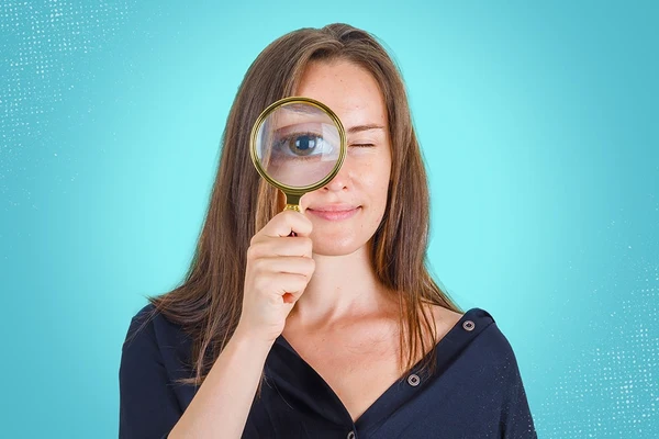 A woman with a magnifying glass showing how to identify Hangxiety symptoms