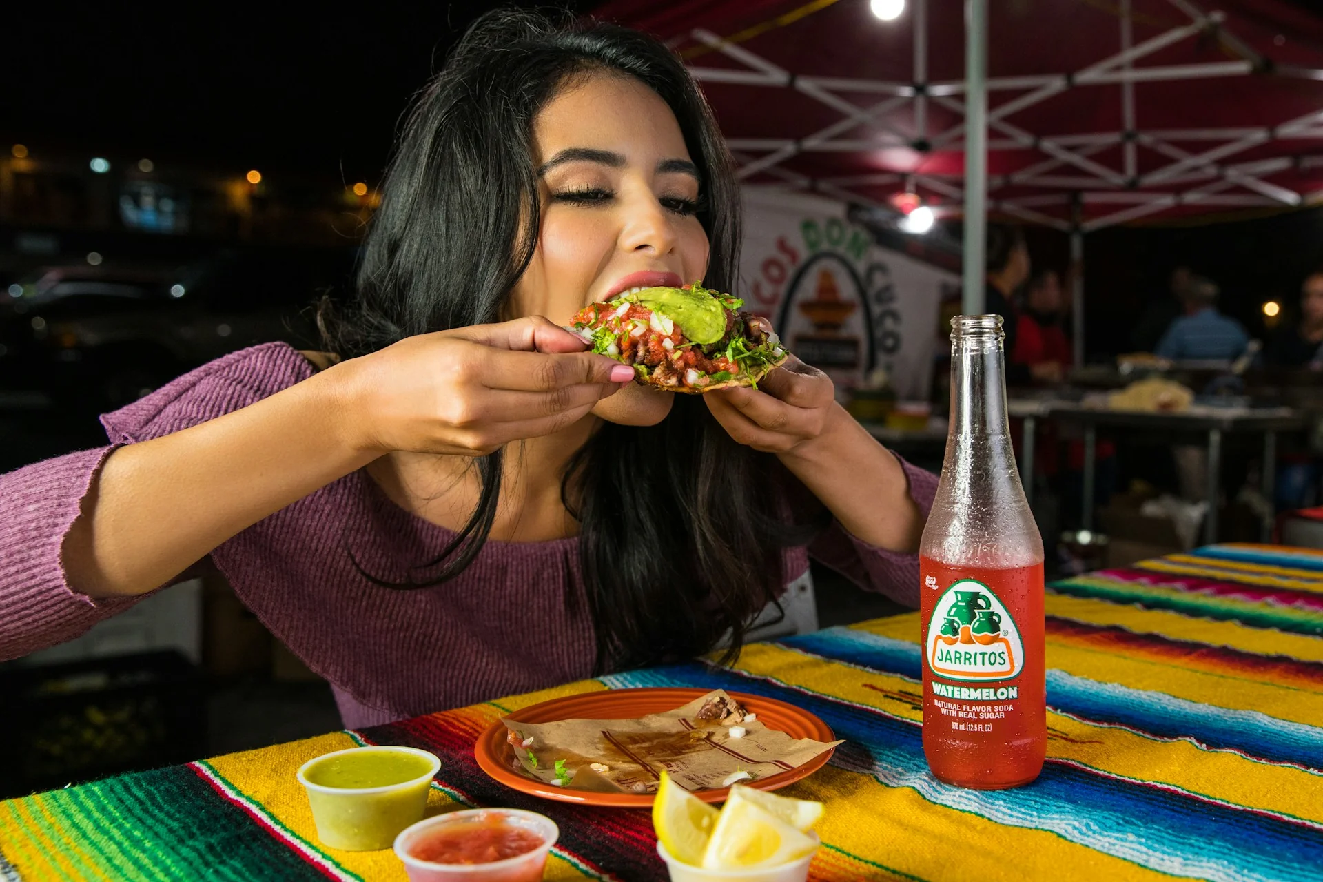 A girl eats a burrito with soda with the munchies