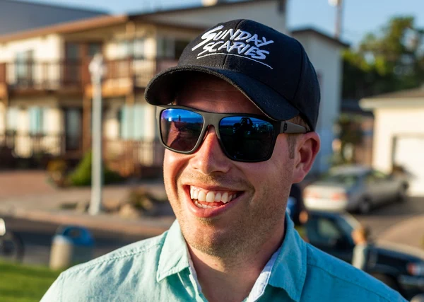 A photo of Beau Schmitt, CGO & Co-founder of Sunday Scaries, wearing a Sunday Scaries hat and sunglasses