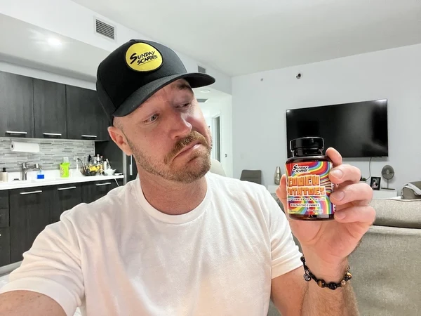 CEO of Sunday Scaries, Mike Sill, holds up a bottle of Couch Potatoes