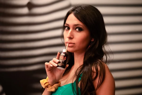 A girl sips on a drink from Sunday Scaries while having a judging look on her face