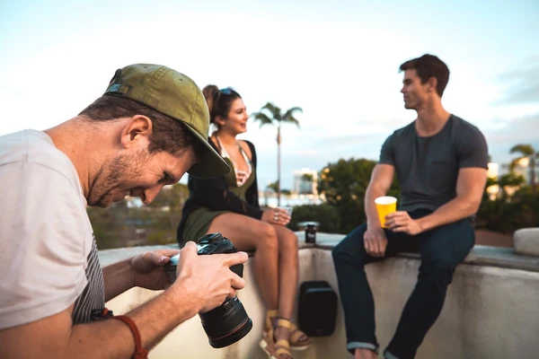 A guy takes a picture of two Sunday Scaries models sitting on a ledge