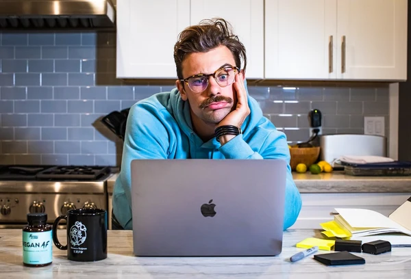 A guy with glasses is working from home and has meeting anxiety