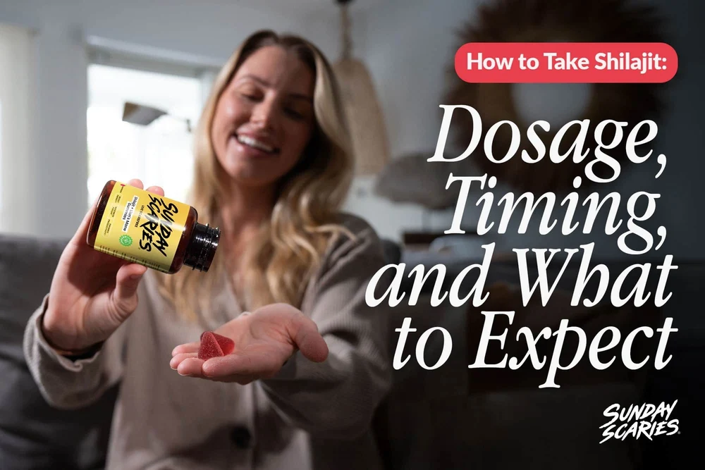 A woman sits on her couch and pours two shilajit gummies into her hand. 