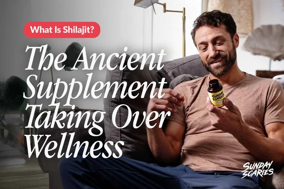 A man looking at the back of a Sunday Scaries Shilajit gummies bottle while sitting on the couch. 