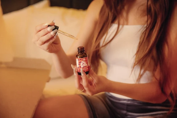 A girl sits in bed 30 minutes before bedtime showing when to take CBD oil for sleep