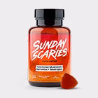 A bottle of Sunday Scaries Functional Mushroom Gummies with one gummy visible in front of the bottle.