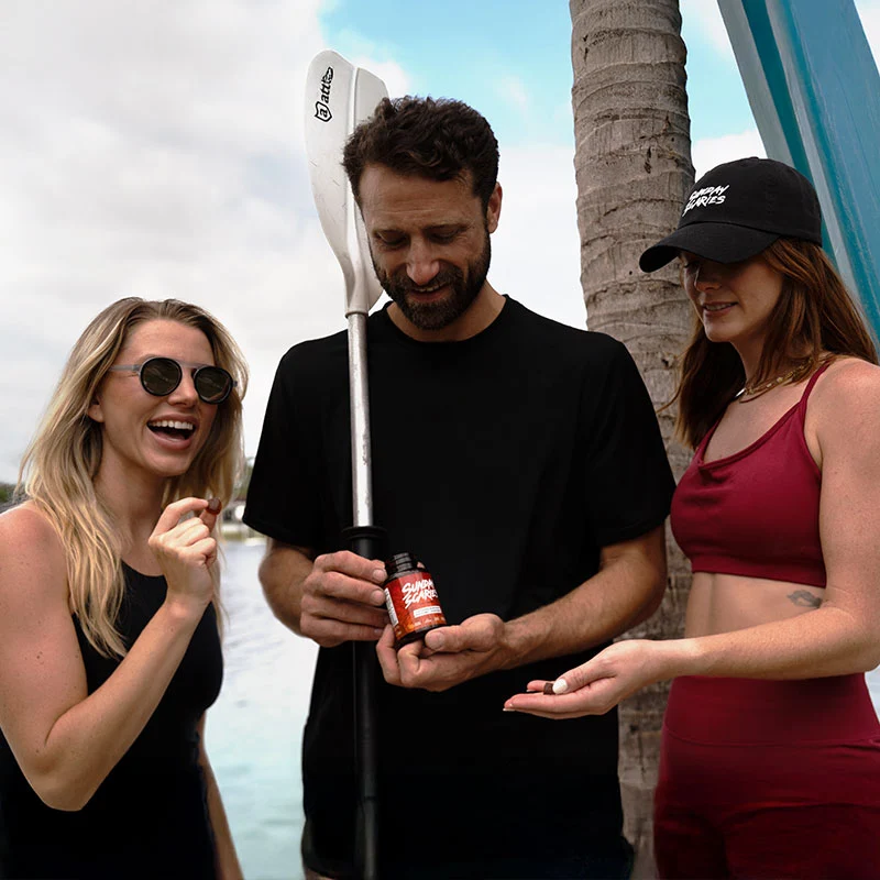 A group of friends take Sunday Scaries mushroom gummies before paddle boarding to help keep their focus.