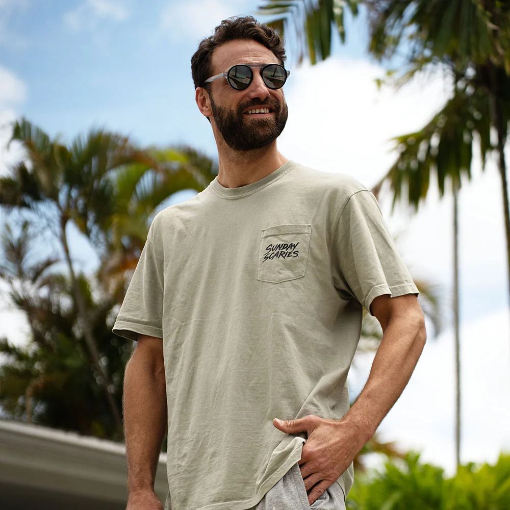 A male poses in the backyard wearing his pocket tee