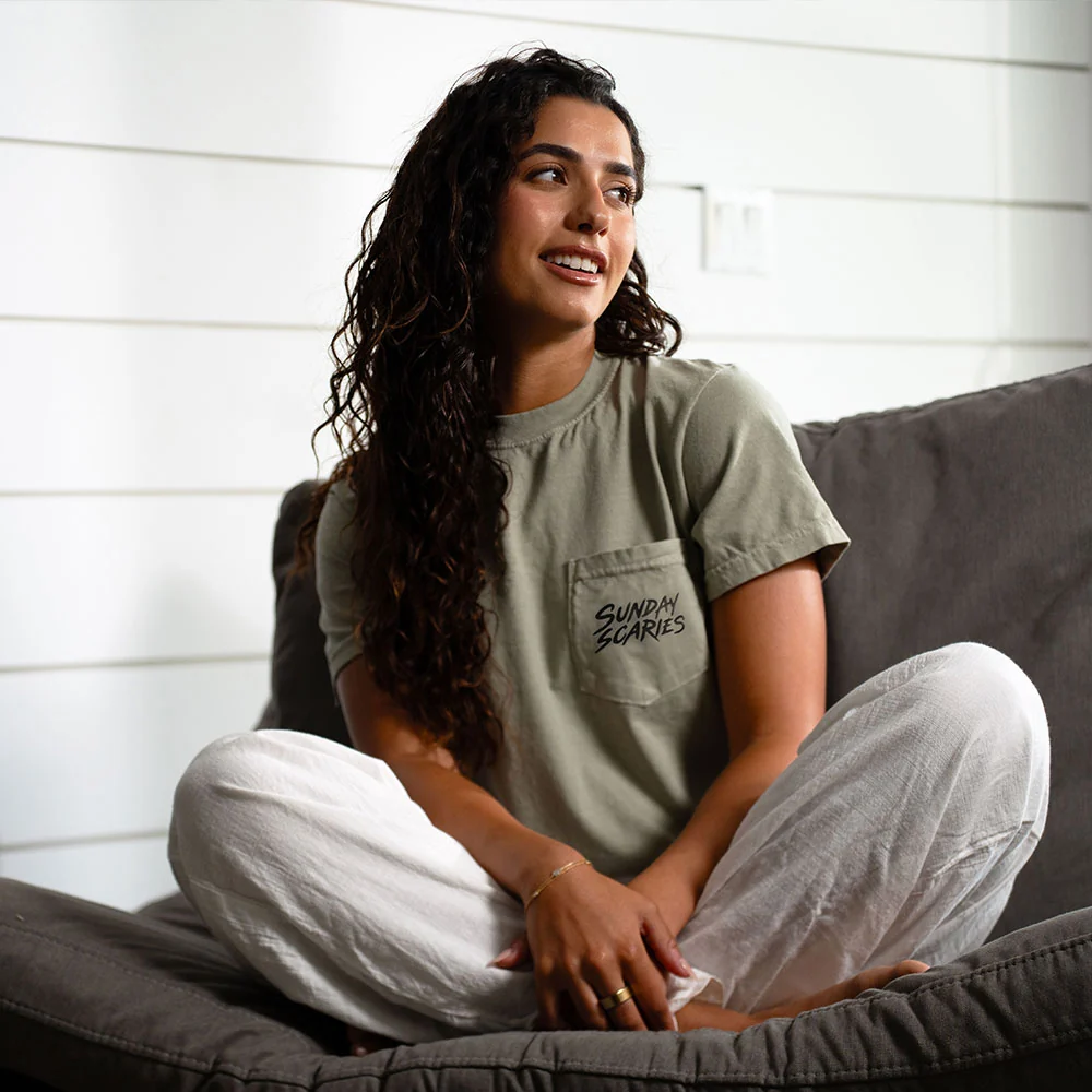 A female model shows off her sandstone Sunday Scaries pocket tee